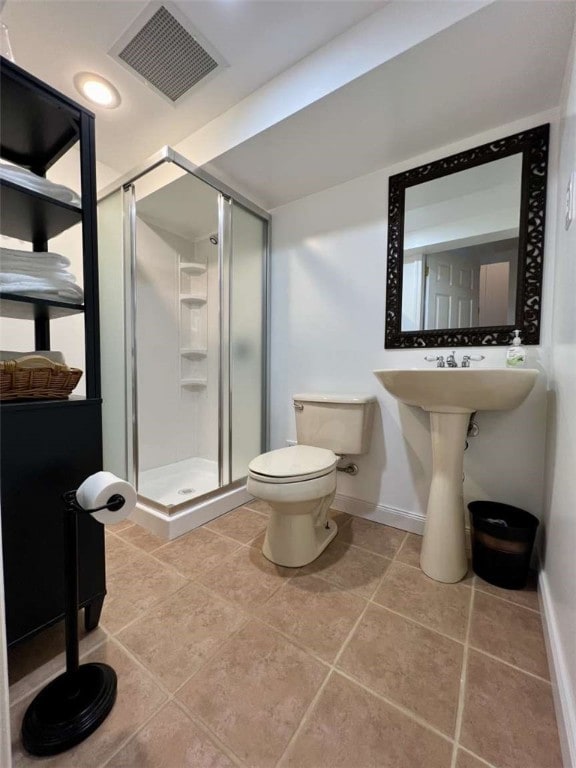 bathroom featuring a shower with shower door, tile patterned floors, and toilet