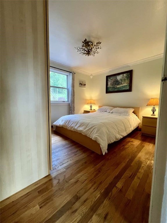 bedroom with wood-type flooring and ornamental molding