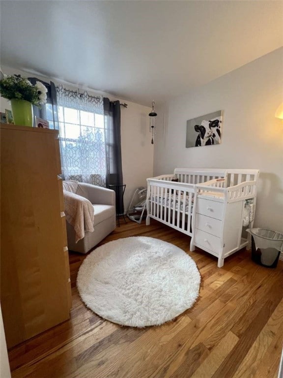 bedroom featuring light hardwood / wood-style floors and a crib