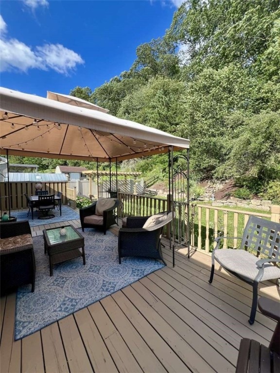 wooden deck featuring a gazebo and outdoor lounge area