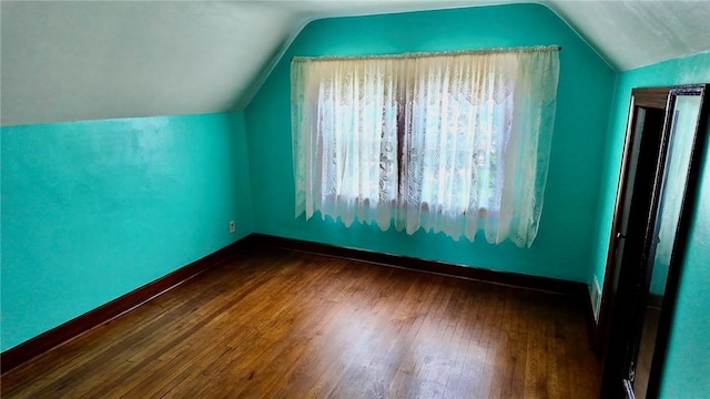 bonus room featuring a healthy amount of sunlight, vaulted ceiling, and dark wood-type flooring