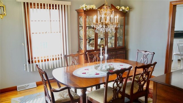 dining space with an inviting chandelier, light hardwood / wood-style flooring, and a wealth of natural light