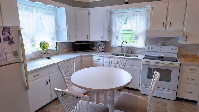 kitchen with sink, white appliances, tasteful backsplash, and white cabinets