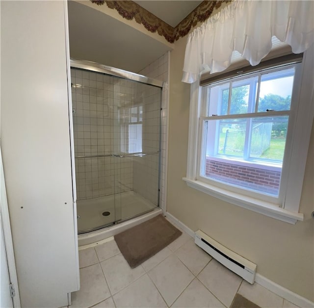 bathroom featuring tile patterned flooring, a baseboard heating unit, and an enclosed shower