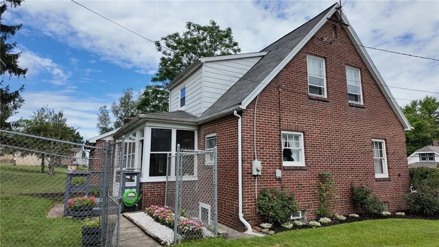 view of side of property featuring a sunroom and a yard