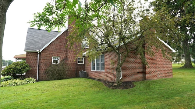 view of home's exterior with a yard and central AC