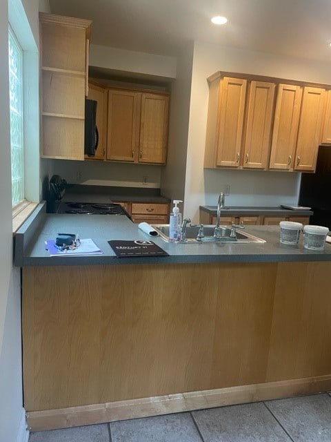 kitchen featuring sink, light tile patterned floors, and kitchen peninsula