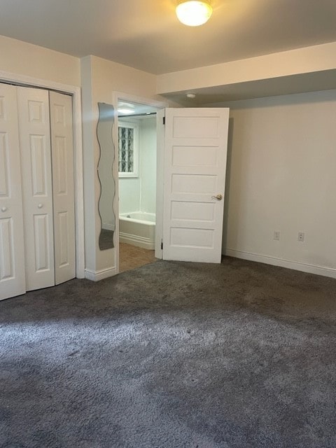 unfurnished bedroom featuring carpet flooring, a closet, and ensuite bathroom