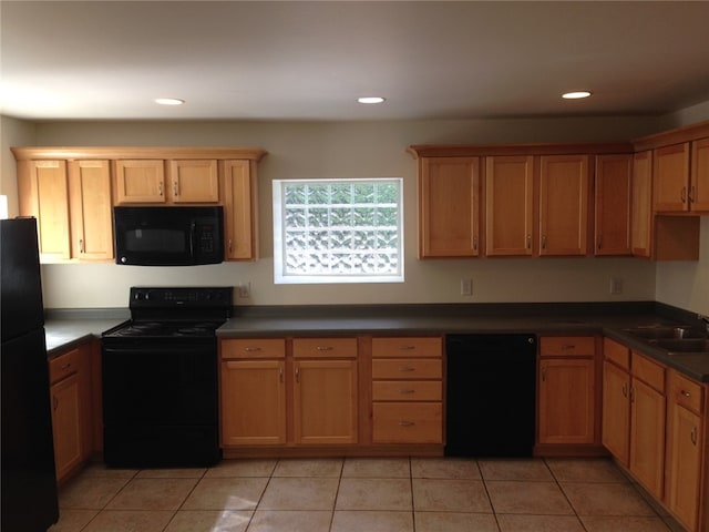 kitchen featuring sink, light tile patterned flooring, and black appliances