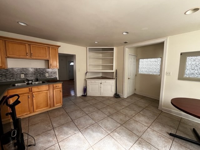 kitchen featuring tile patterned floors, tasteful backsplash, and sink