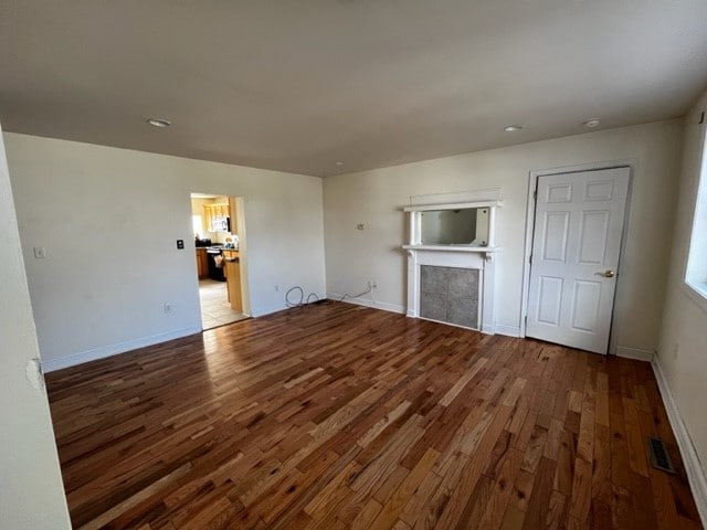 unfurnished living room featuring a fireplace and hardwood / wood-style floors