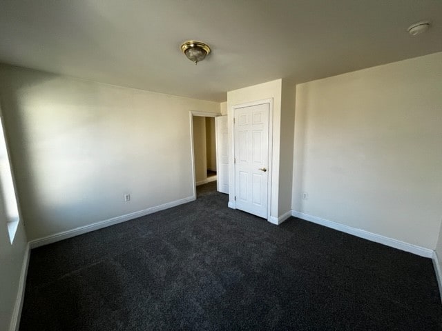 unfurnished bedroom featuring dark colored carpet