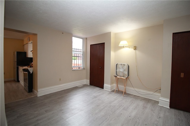 unfurnished room with a textured ceiling and hardwood / wood-style flooring