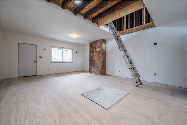 unfurnished living room featuring beam ceiling