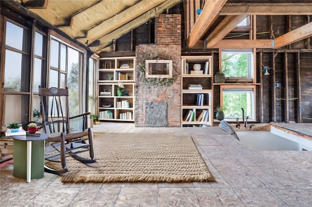 miscellaneous room with beam ceiling and high vaulted ceiling