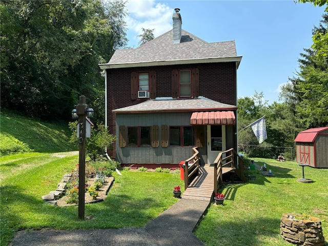 view of front of house with a storage shed, cooling unit, and a front yard