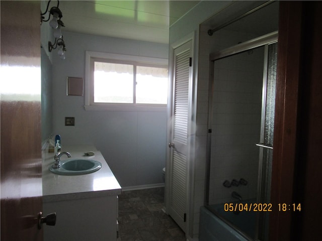 full bathroom featuring vanity, tile patterned floors, toilet, and enclosed tub / shower combo