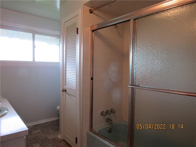 full bathroom featuring vanity, toilet, tile patterned flooring, and enclosed tub / shower combo