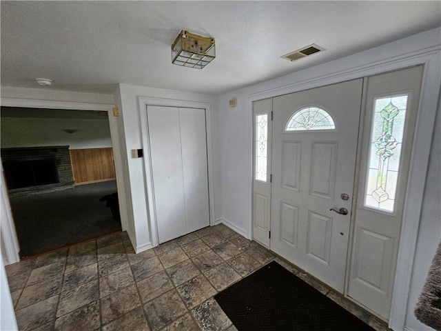 entryway with a healthy amount of sunlight and a brick fireplace