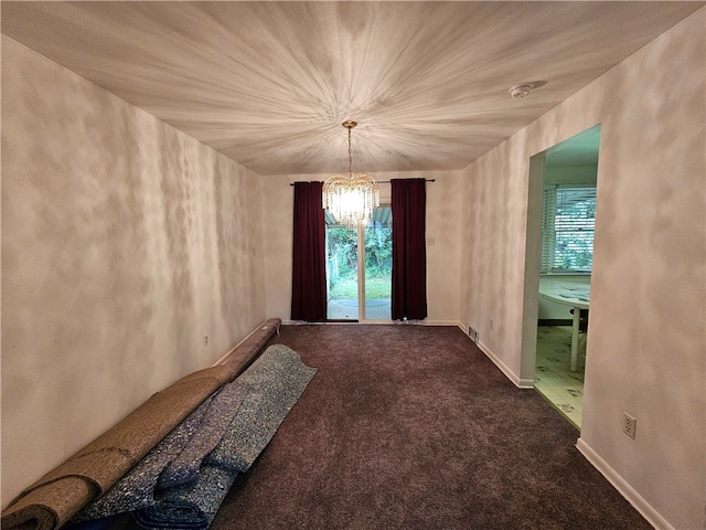 carpeted spare room with a chandelier