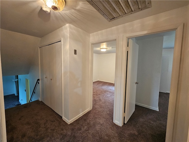 corridor featuring dark colored carpet