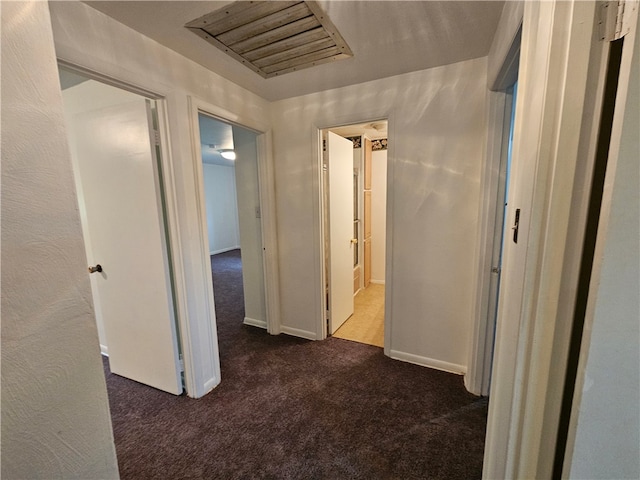 hallway featuring dark carpet