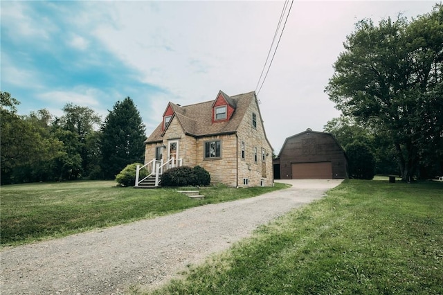 view of front of property featuring an outbuilding, a garage, and a front yard