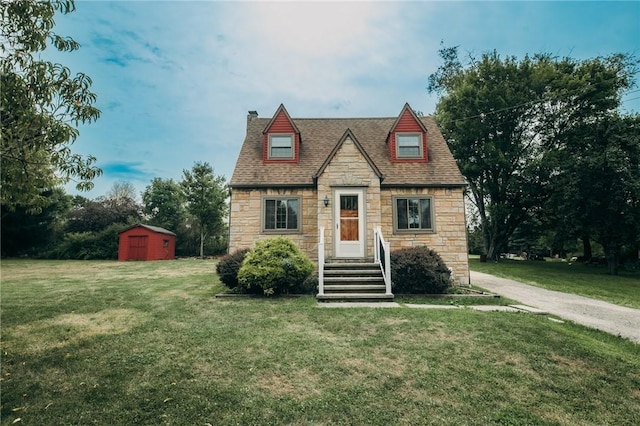 tudor home featuring a storage shed and a front lawn