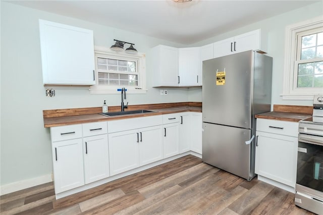 kitchen featuring appliances with stainless steel finishes, butcher block counters, and white cabinets