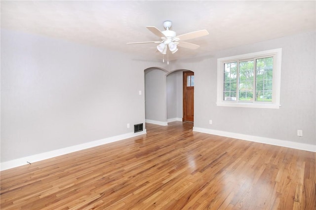 empty room with ceiling fan and light hardwood / wood-style flooring