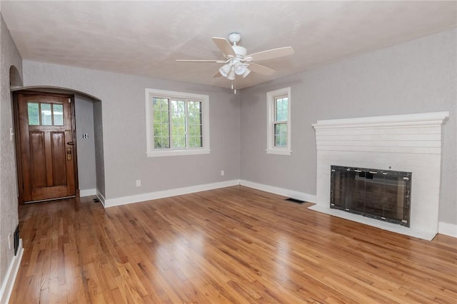 unfurnished living room with ceiling fan and wood-type flooring