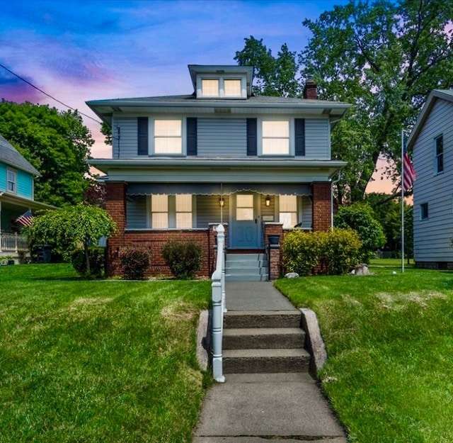 view of front of house with covered porch and a yard