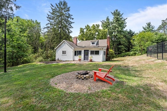 rear view of house featuring a lawn and an outdoor fire pit