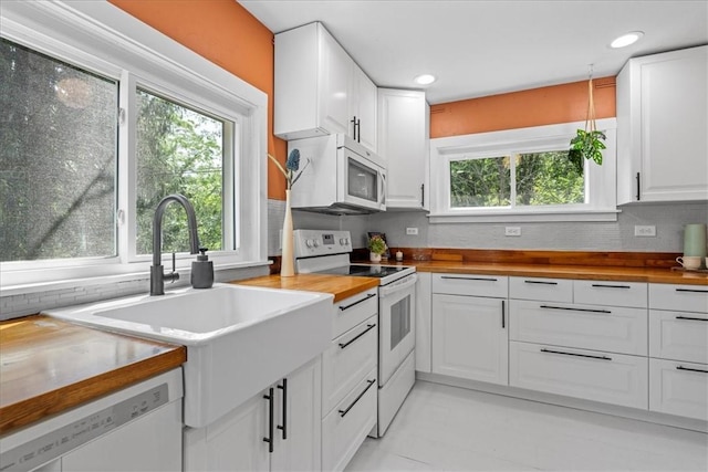 kitchen featuring white cabinetry, white appliances, wooden counters, and backsplash