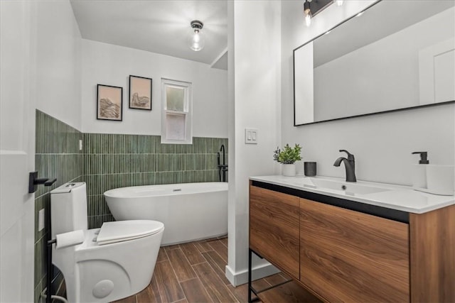 bathroom featuring vanity, a bath, tile walls, and toilet