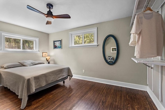 bedroom with ceiling fan, dark hardwood / wood-style flooring, and multiple windows