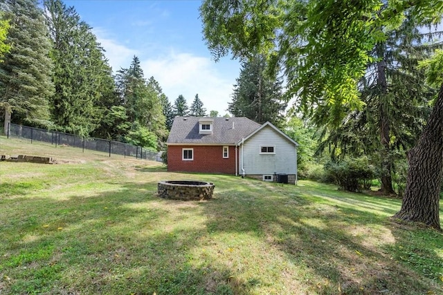 rear view of house featuring an outdoor fire pit and a yard