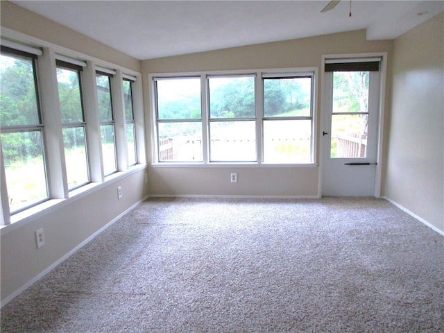 unfurnished room featuring carpet flooring, a healthy amount of sunlight, and vaulted ceiling