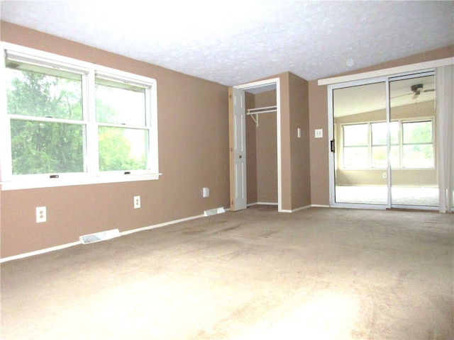 unfurnished bedroom with carpet and multiple windows