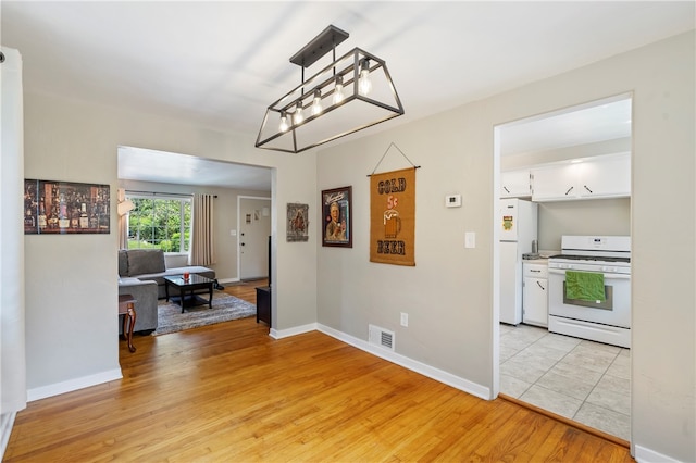 interior space with light hardwood / wood-style flooring and a notable chandelier