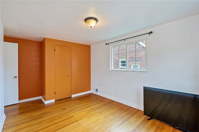 unfurnished bedroom with light wood-type flooring and a closet