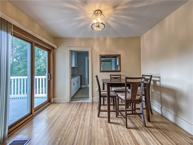 dining room featuring an inviting chandelier and light wood-type flooring