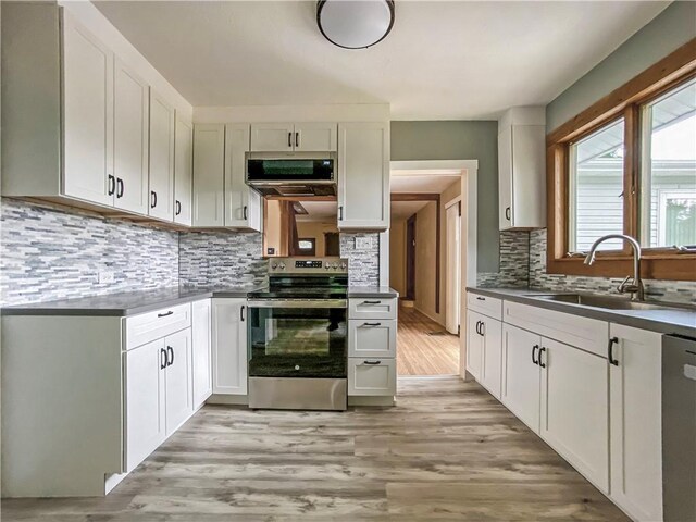 kitchen featuring sink, light hardwood / wood-style floors, appliances with stainless steel finishes, and backsplash