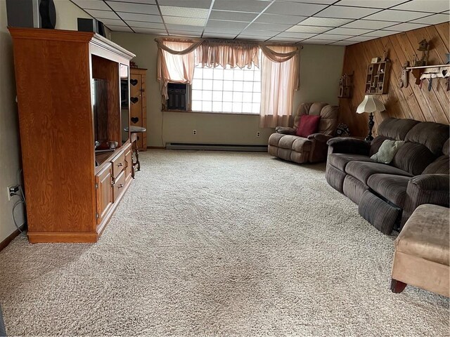 living room featuring wood walls, light carpet, a drop ceiling, and baseboard heating