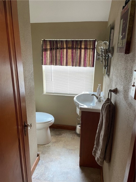 bathroom featuring vanity, tile patterned flooring, and toilet