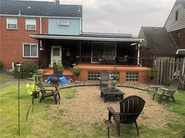 rear view of property featuring a yard and an outdoor fire pit