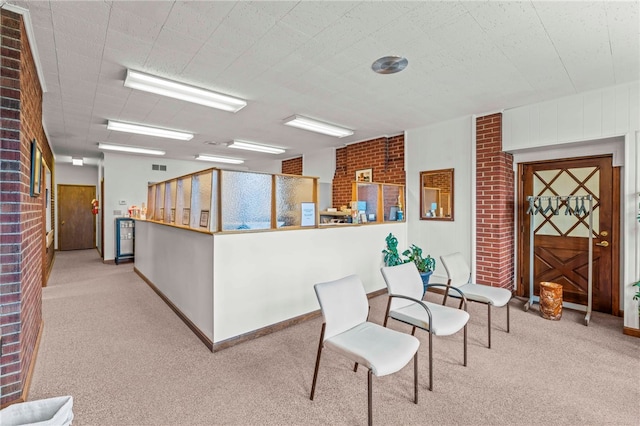 interior space featuring light colored carpet and brick wall