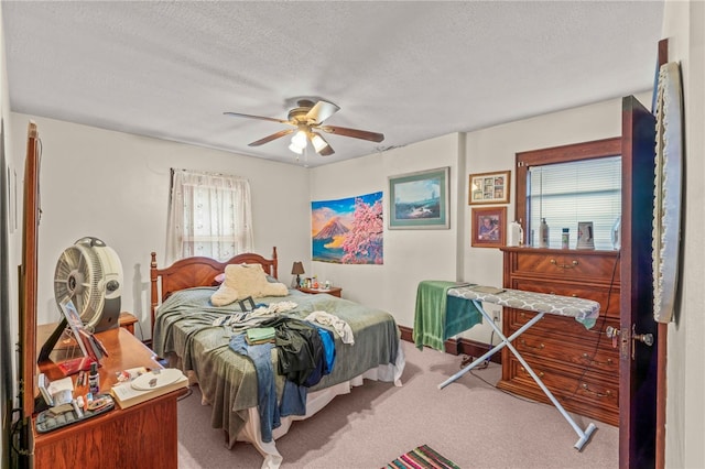 carpeted bedroom featuring a textured ceiling and ceiling fan