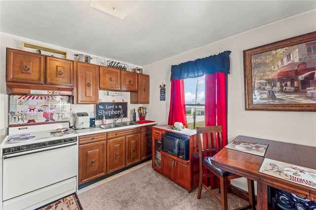 kitchen featuring white range with electric cooktop, sink, black microwave, and wall chimney range hood