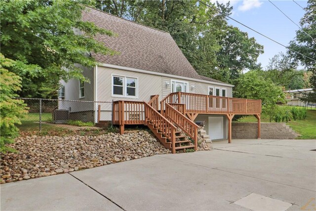 view of front facade with a garage, a deck, and central AC unit